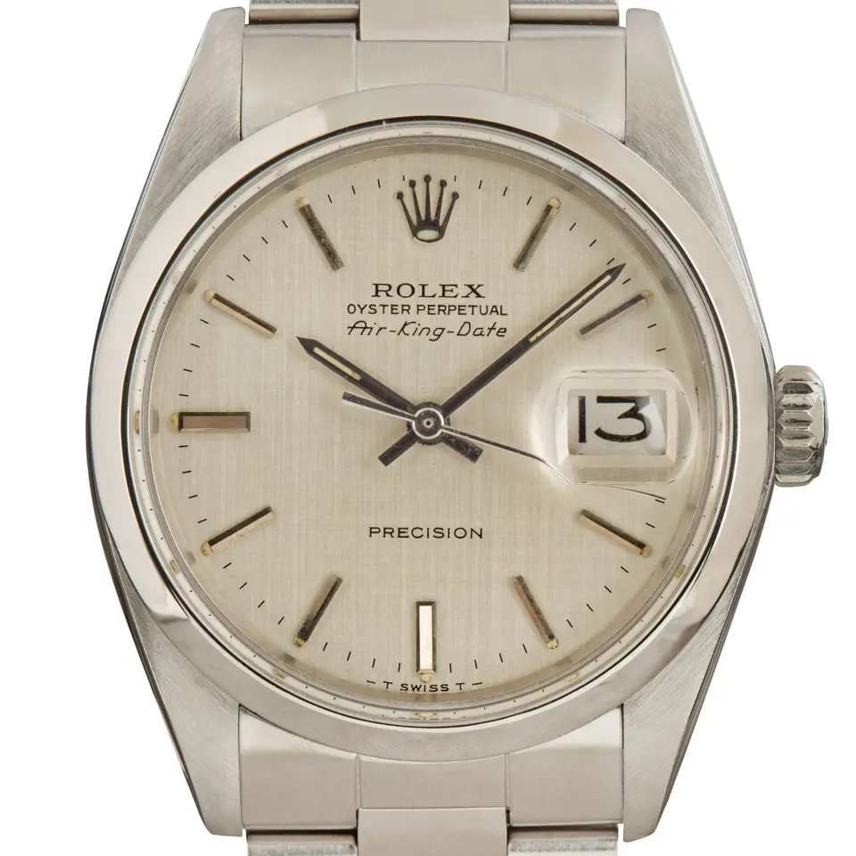 Rolex Air-King Date 5700 with a silver dial with date window and smooth steel bezel on an Oyster bracelet, a pre-owned example, studio close-up of the case