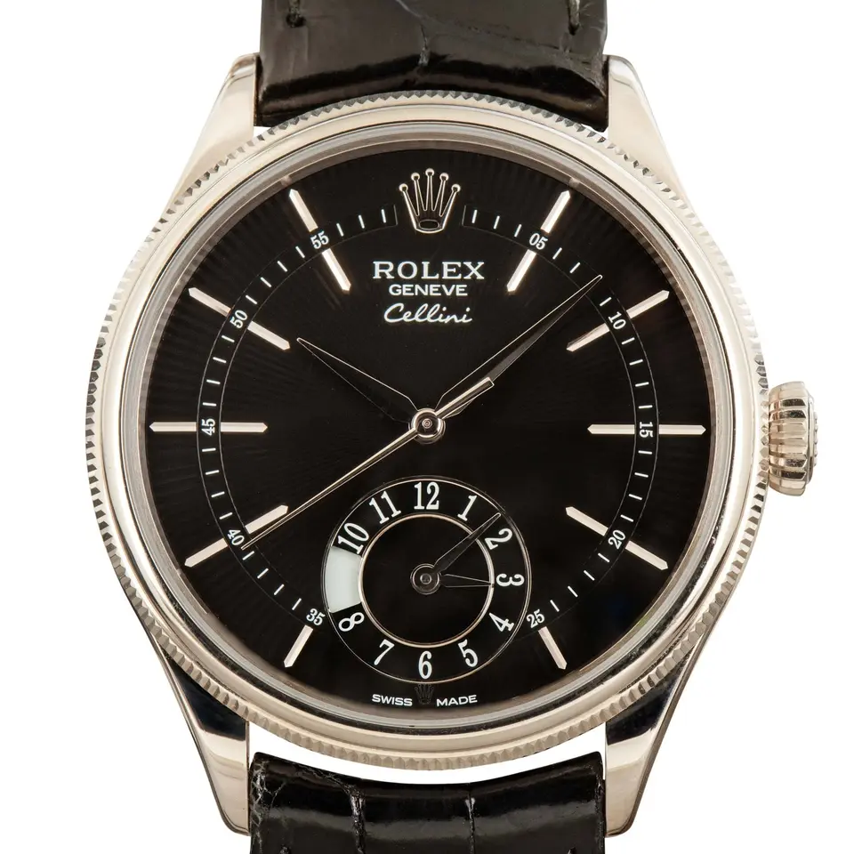 Rolex Cellini Dual Time 50529 with a black dial with second time zone sub-dial and fluted white gold bezel on a black leather strap, a pre-owned example, studio close-up of the case