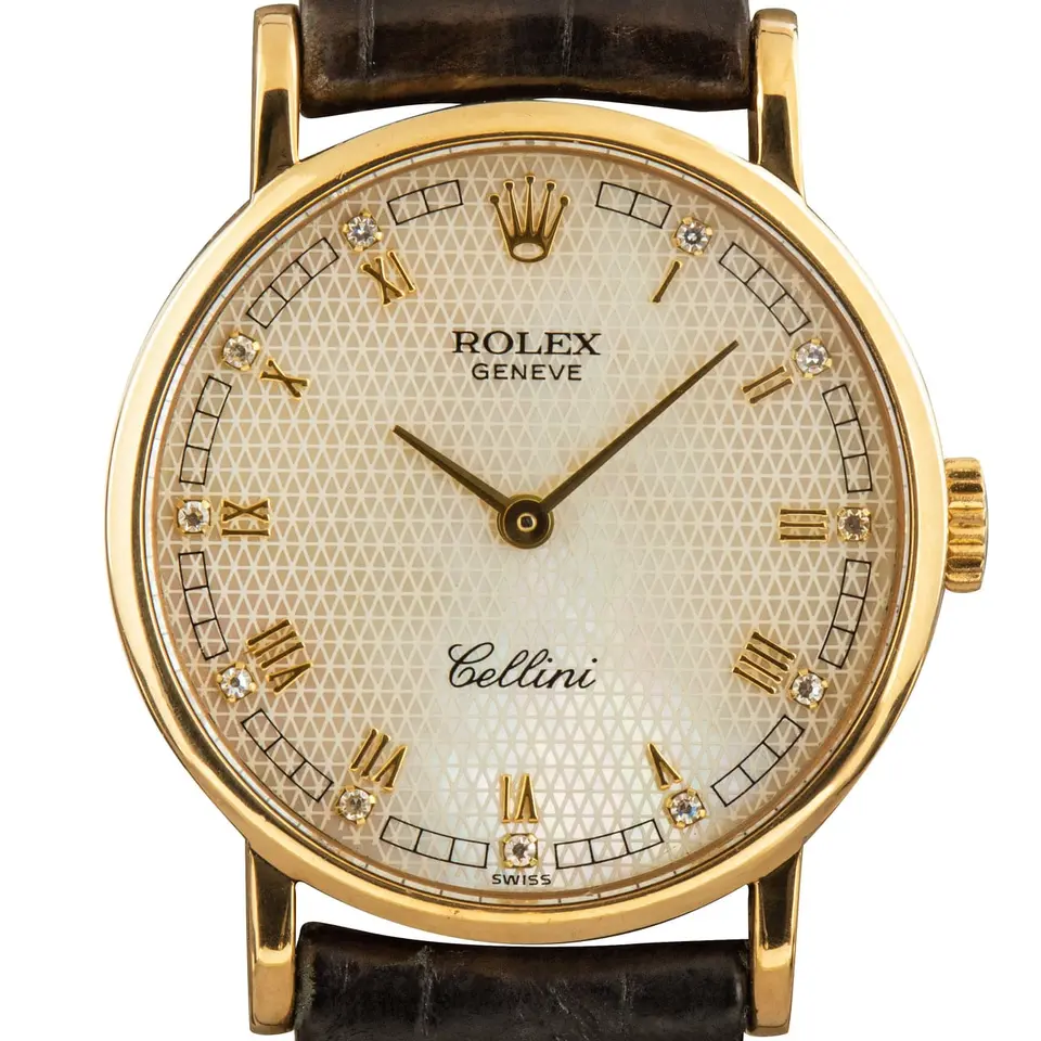 Rolex Cellini 5109 with a silver guilloché Roman-numeral dial, round yellow gold case on a black leather strap, a pre-owned example, studio close-up of the case
