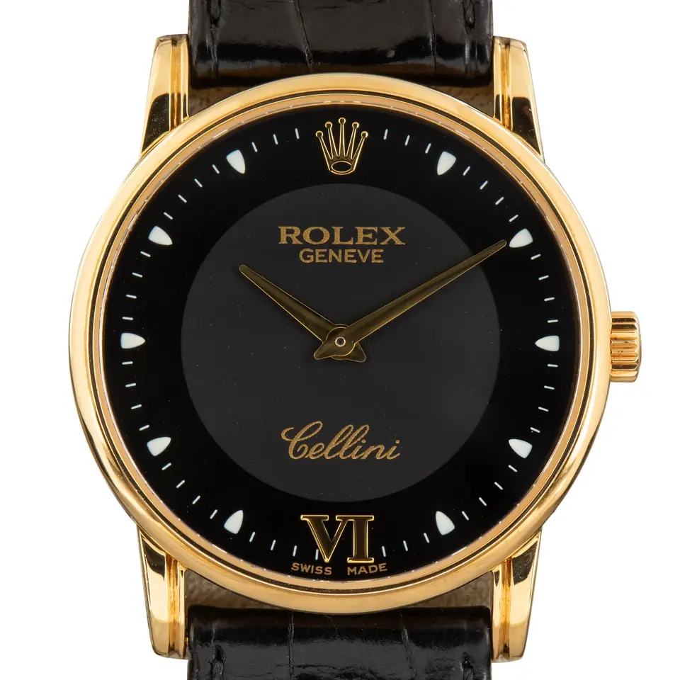Rolex Cellini 5116 with a black dial with Roman numerals, round yellow gold case on a black leather strap, a pre-owned example, studio close-up of the case