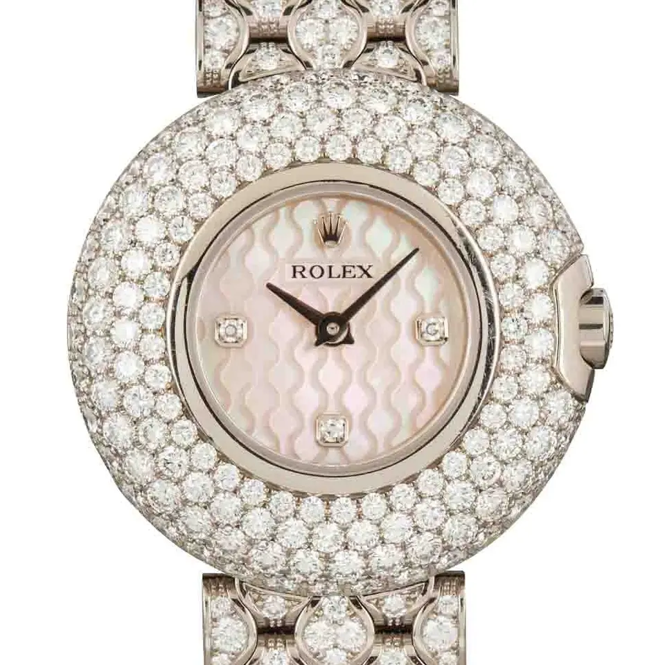 Rolex Cellini 6221 with a pink mother-of-pearl dial, pavé diamond-set round case and diamond-set white gold bracelet, a pre-owned example, studio close-up of the case