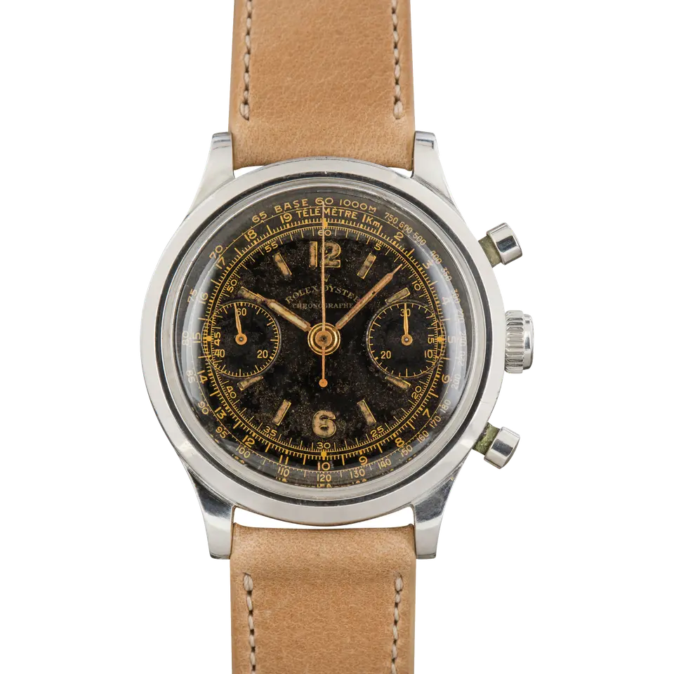 Rolex Chronograph 3525 with a black chronograph dial with gold numerals and tachymeter scale, steel case on a beige leather strap, a pre-owned example, front view of the whole watch