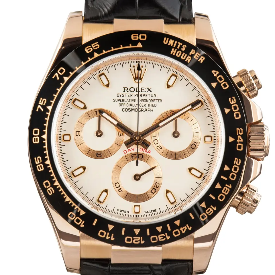 Rolex Cosmograph Daytona 116515LN with an ivory dial with gold counters and a black ceramic tachymeter bezel in Everose gold on a black strap, a pre-owned example, studio close-up of the case