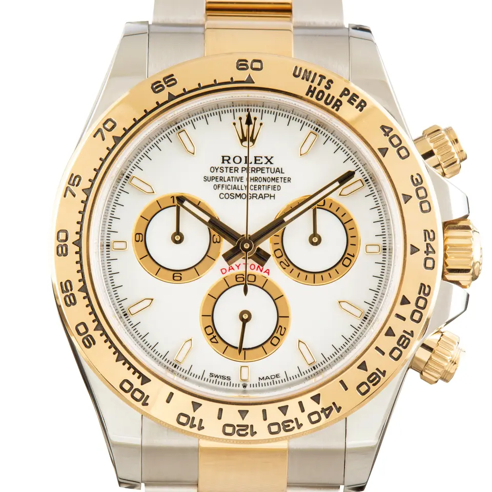 Rolex Cosmograph Daytona 126503 with a white dial with golden counters and a yellow gold tachymeter bezel, a pre-owned example, studio close-up of the case