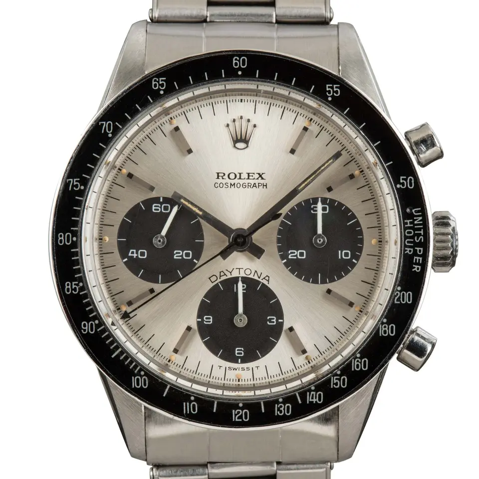 Rolex Cosmograph Daytona 6241 with a silver dial with black sub-dials and a black tachymeter bezel insert on a steel Oyster bracelet, a pre-owned example, studio close-up of the case