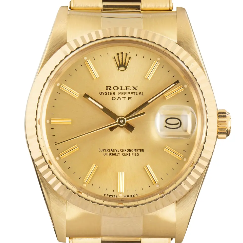 Rolex Date 15037 with a champagne dial, fluted yellow gold bezel and yellow gold Oyster bracelet, a pre-owned example, studio close-up of the case