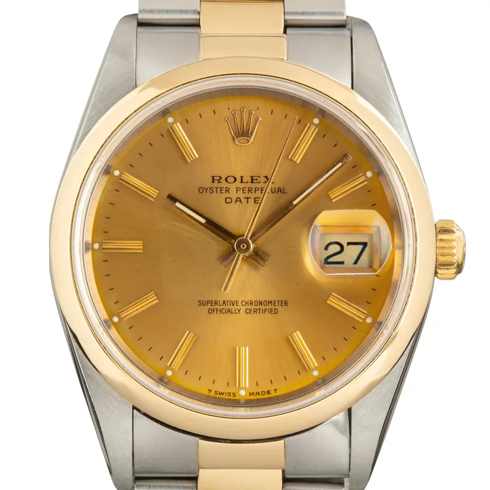 Rolex Oyster Perpetual Date 34 15203 with a champagne dial, smooth yellow gold bezel and steel and gold Oyster bracelet, a pre-owned example, studio close-up of the case