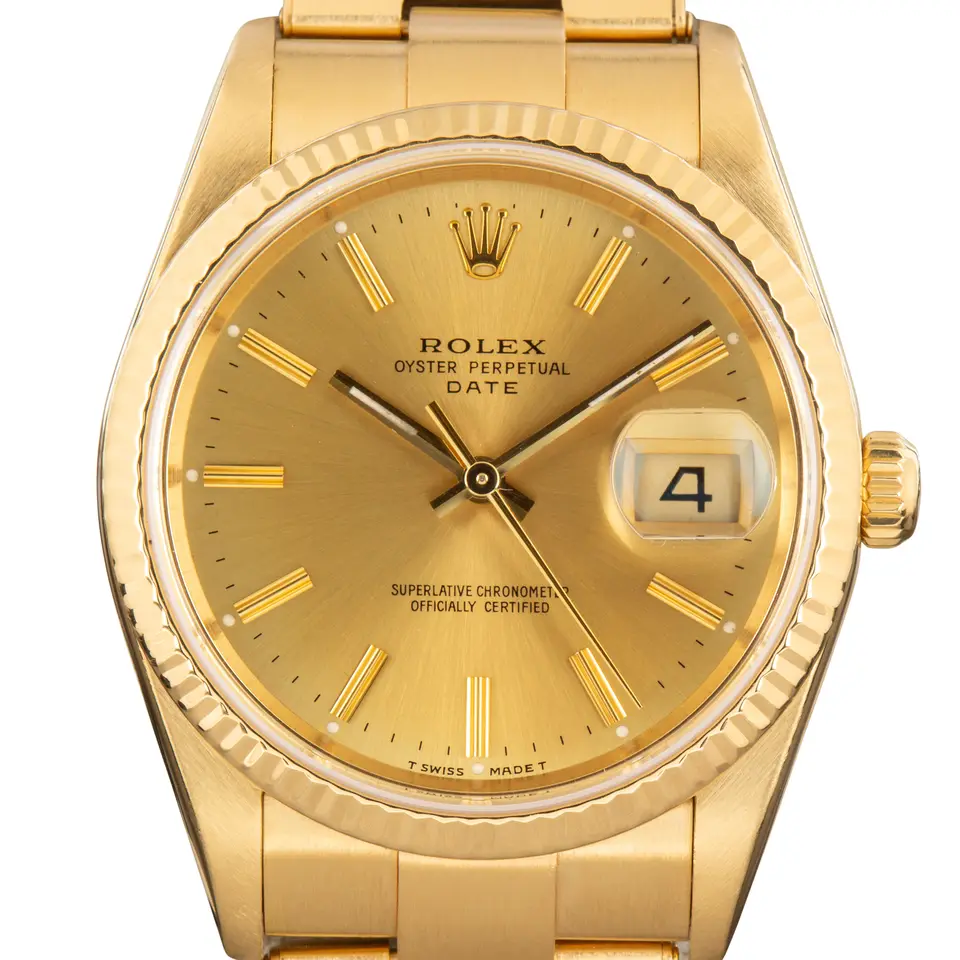 Rolex Oyster Perpetual Date 34 15238 with a champagne dial, fluted yellow gold bezel and yellow gold Oyster bracelet, a pre-owned example, studio close-up of the case