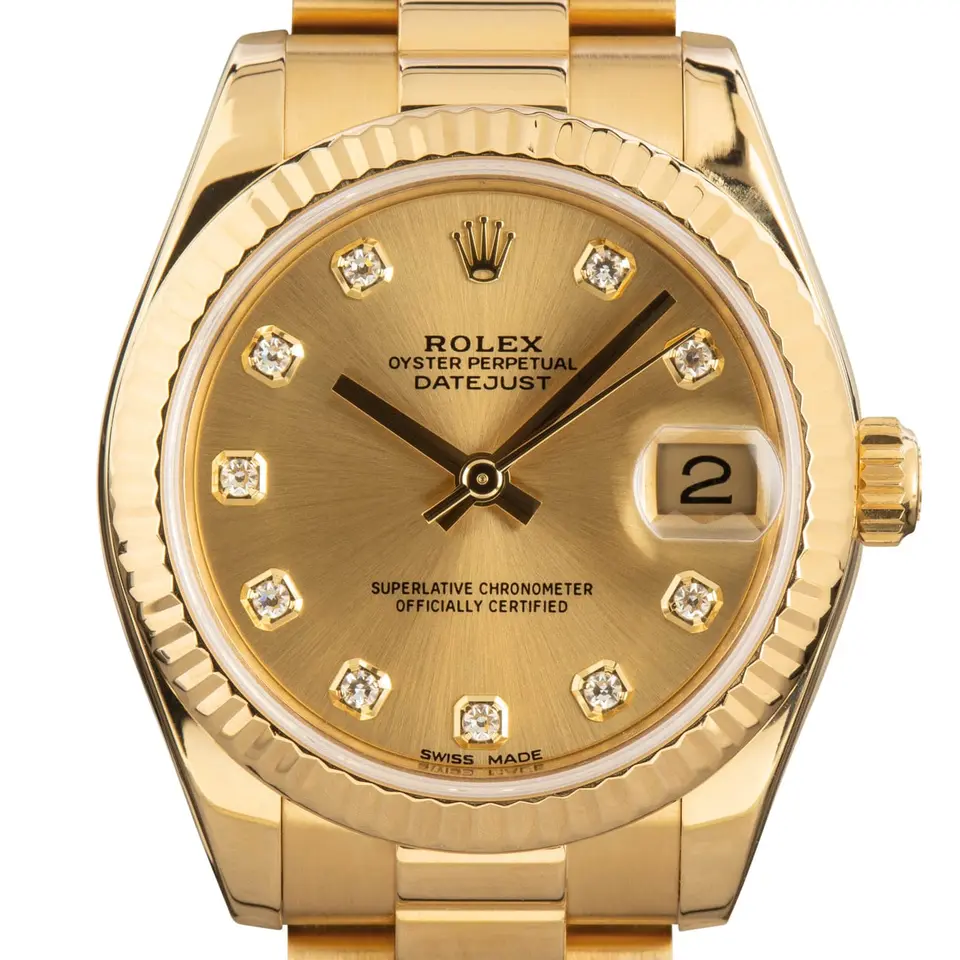Rolex Datejust 31 178278 with a champagne dial with diamond markers and fluted bezel in yellow gold on a President bracelet, a pre-owned example, studio close-up of the case