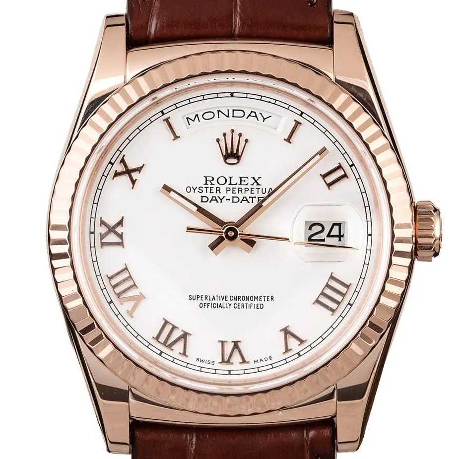 Rolex Day-Date 36 118135 with a white dial with Roman numerals and fluted bezel in Everose gold on a brown leather strap, a pre-owned example, studio close-up of the case