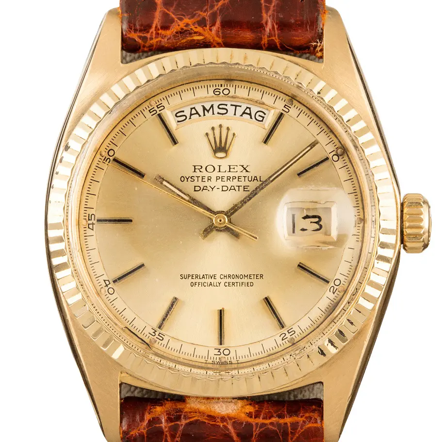 Rolex Day-Date 36 1802 with a champagne dial with a German day disc, fluted yellow gold bezel and yellow gold case on a brown leather strap, a pre-owned example, studio close-up of the case