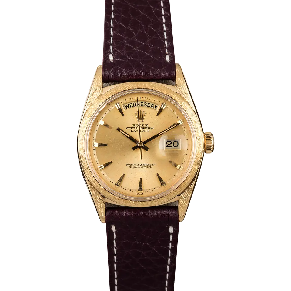 Rolex Day-Date 1806 with a champagne dial with baton markers and a textured yellow gold bezel on a black leather strap, a pre-owned example, front view of the whole watch