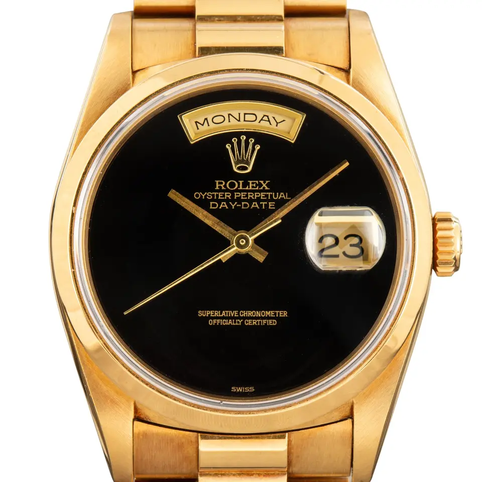 Rolex Day-Date 36 18208 with a black onyx dial, smooth yellow gold bezel and yellow gold President bracelet, a pre-owned example, studio close-up of the case