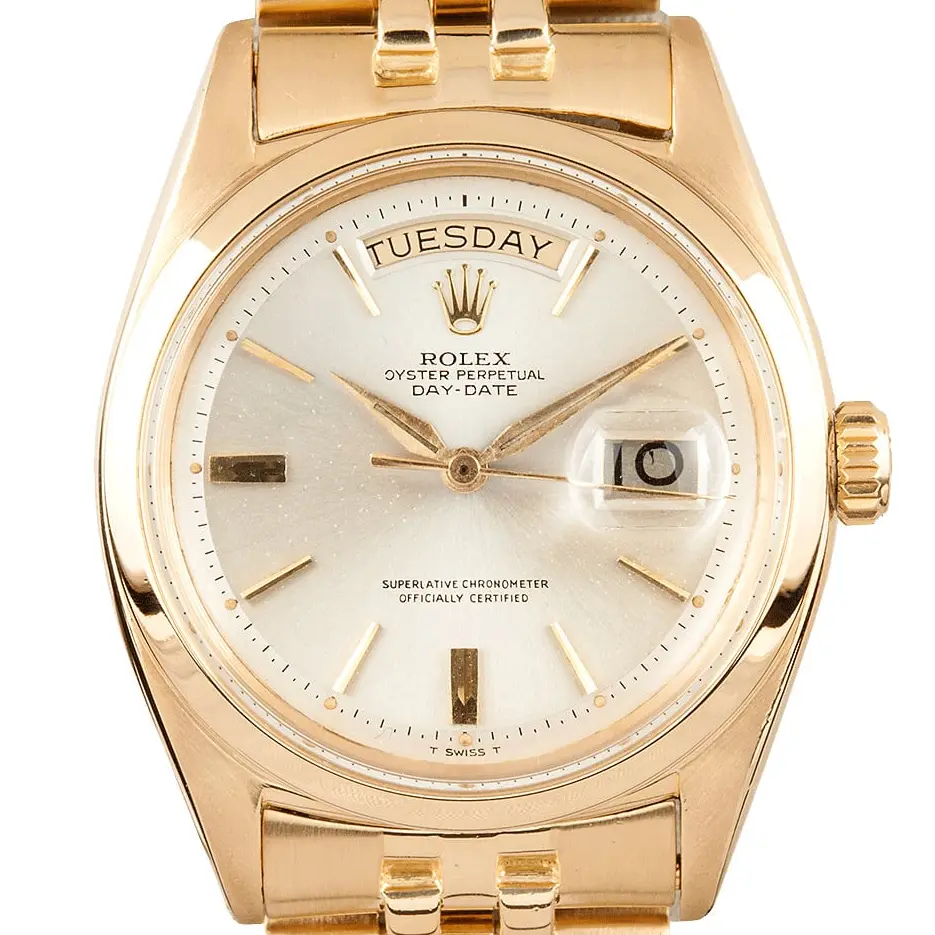 Rolex Day-Date 6612 with a silver dial with baton markers and a smooth yellow gold bezel on a yellow gold President bracelet, a pre-owned example, studio close-up of the case