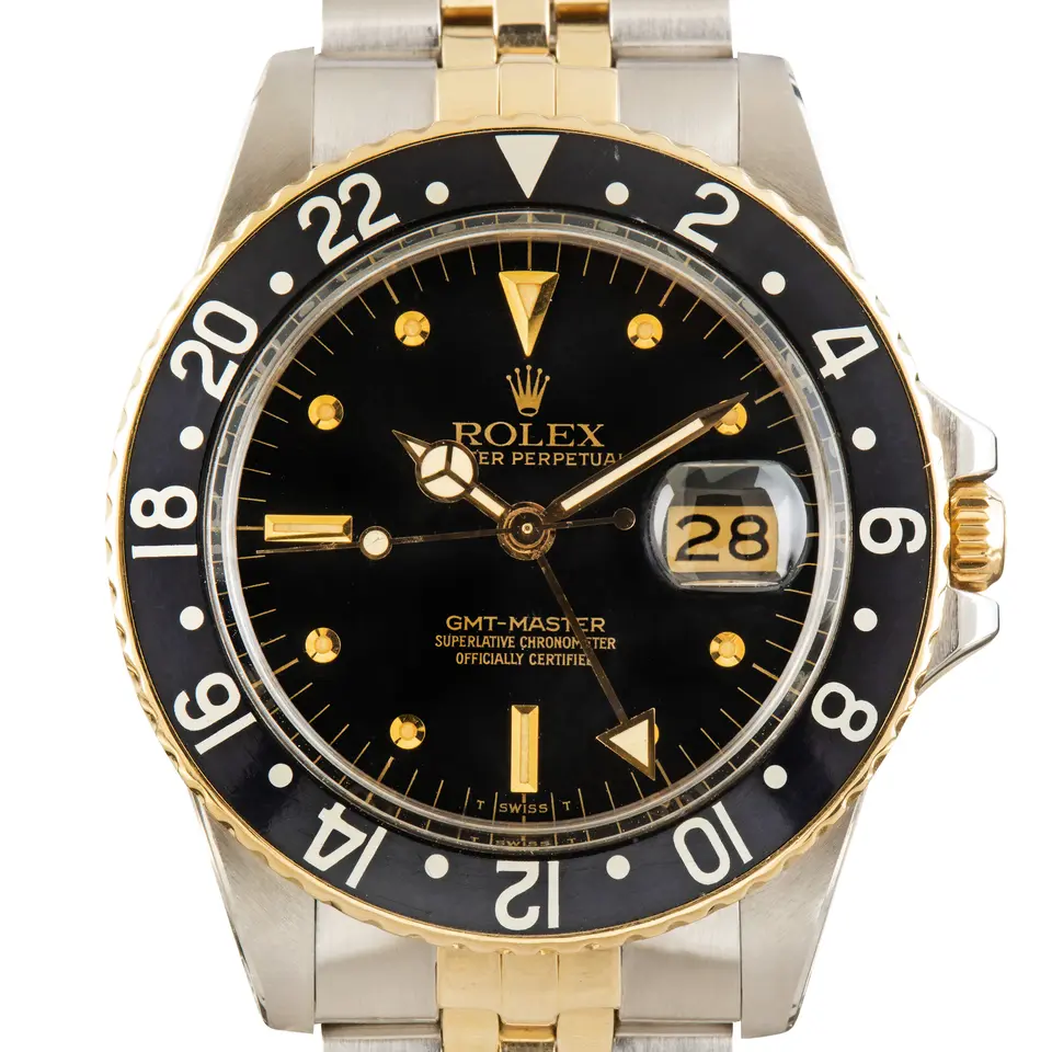 Rolex GMT-Master 16753 with a black dial with round gold markers and a black 24-hour bezel insert on a two-tone Jubilee bracelet, a pre-owned example, studio close-up of the case