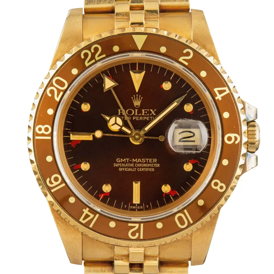 Rolex GMT-Master 16758 with a brown dial with round gold markers and brown bezel in yellow gold on a Jubilee bracelet, a pre-owned example, studio close-up of the case