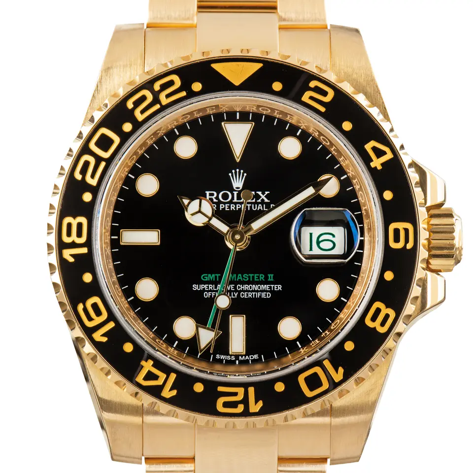 Rolex GMT-Master II 116718LN with a black dial with a green GMT-Master II legend and a black ceramic 24-hour bezel with gold numerals on a yellow gold Oyster bracelet, a pre-owned example, studio close-up of the case
