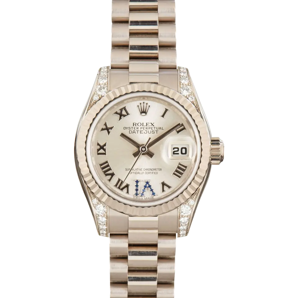 Rolex Lady-Datejust 179239 with a silver Roman-numeral dial with a sapphire-set VI, fluted white gold bezel, diamond-set lugs and white gold President bracelet, a pre-owned example, front view of the whole watch