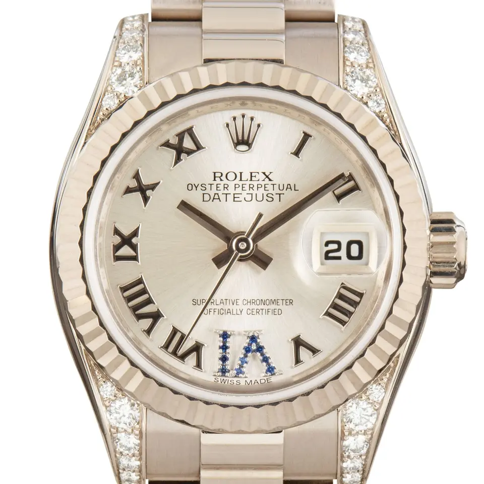 Rolex Lady-Datejust 179239 with a silver Roman-numeral dial with a sapphire-set VI, fluted white gold bezel, diamond-set lugs and white gold President bracelet, a pre-owned example, studio close-up of the case