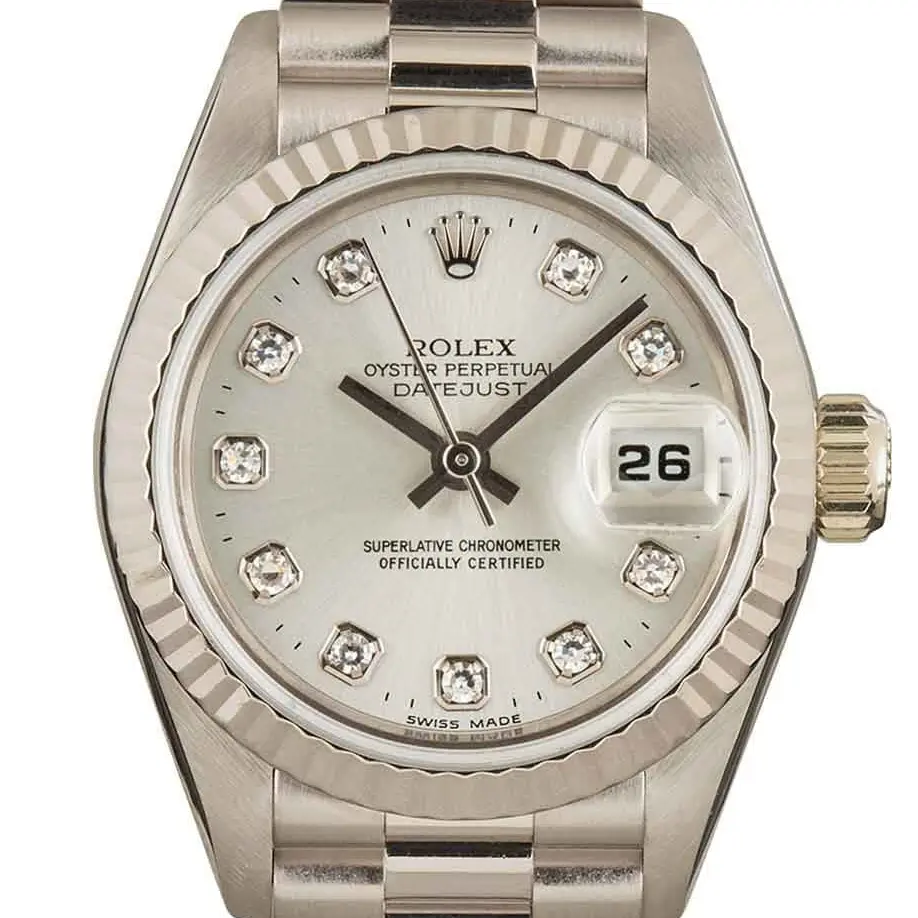 Rolex Lady-Datejust 69179 with a silver dial with diamond hour markers and a fluted white gold bezel on a white gold President bracelet, a pre-owned example, studio close-up of the case