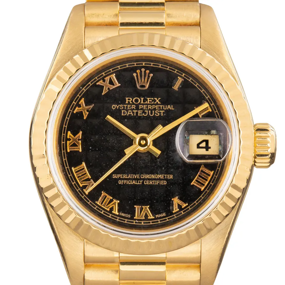 Rolex Lady-Datejust 26 79178 with a black Roman-numeral dial, fluted yellow gold bezel and yellow gold President bracelet, a pre-owned example, studio close-up of the case