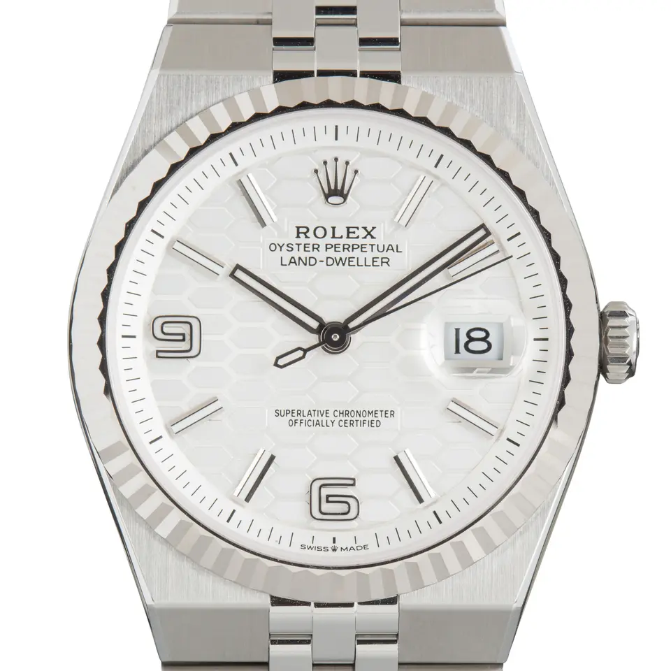 Rolex Land-Dweller 127334 in steel and white gold with an intense white honeycomb-motif dial, fluted white gold bezel and Flat Jubilee bracelet, a pre-owned example, studio close-up of the case