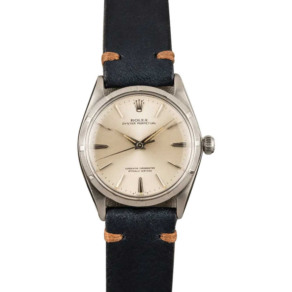 Rolex Oyster Perpetual 1003 with a silver dial, engine-turned steel bezel and steel case on a navy leather strap, a pre-owned example, front view of the whole watch