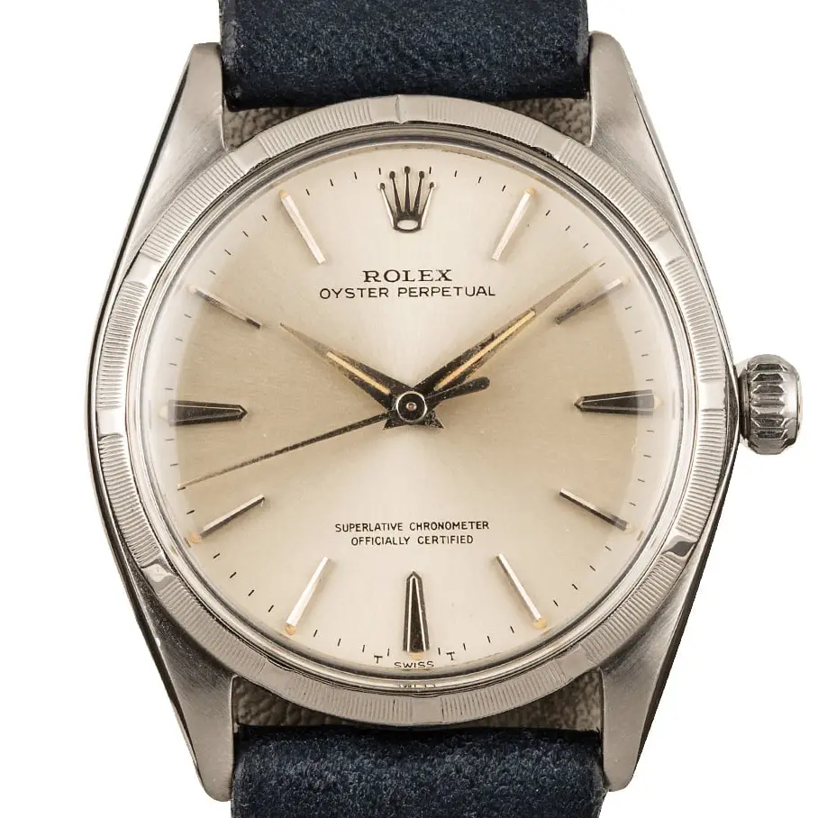 Rolex Oyster Perpetual 1003 with a silver dial, engine-turned steel bezel and steel case on a navy leather strap, a pre-owned example, studio close-up of the case