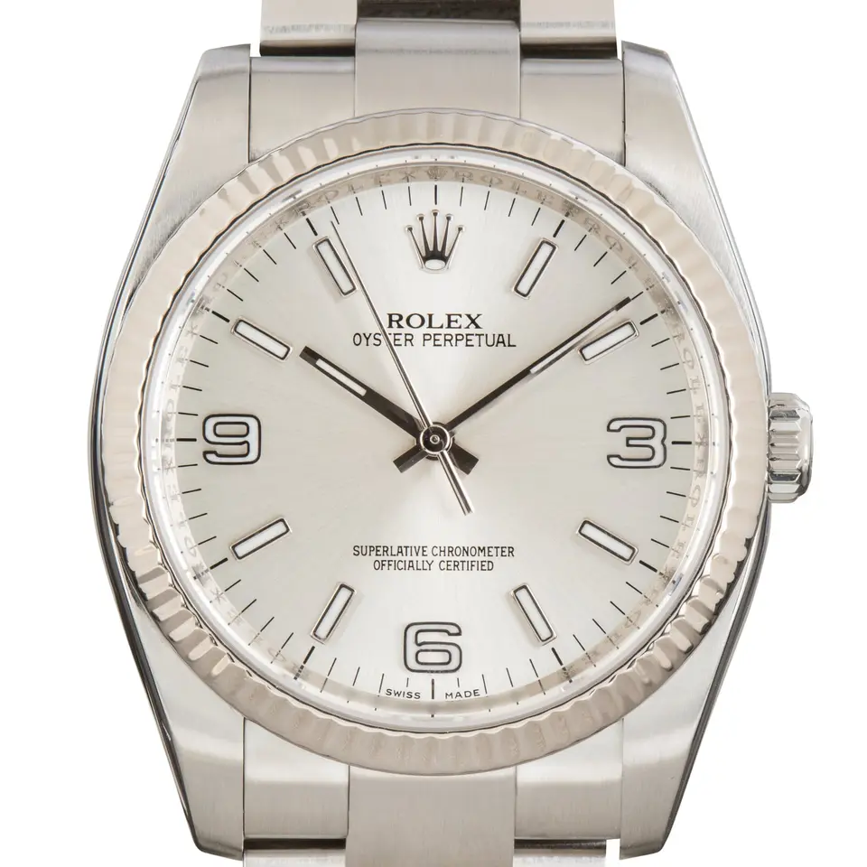Rolex Oyster Perpetual 36 116034 with a silver Arabic-numeral dial, fluted white gold bezel and steel Oyster bracelet, a pre-owned example, studio close-up of the case