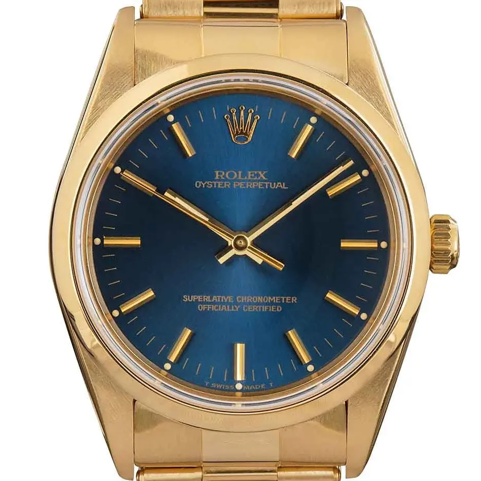 Rolex Oyster Perpetual 34 14208 with a blue dial, smooth yellow gold bezel and yellow gold Oyster bracelet, a pre-owned example, studio close-up of the case
