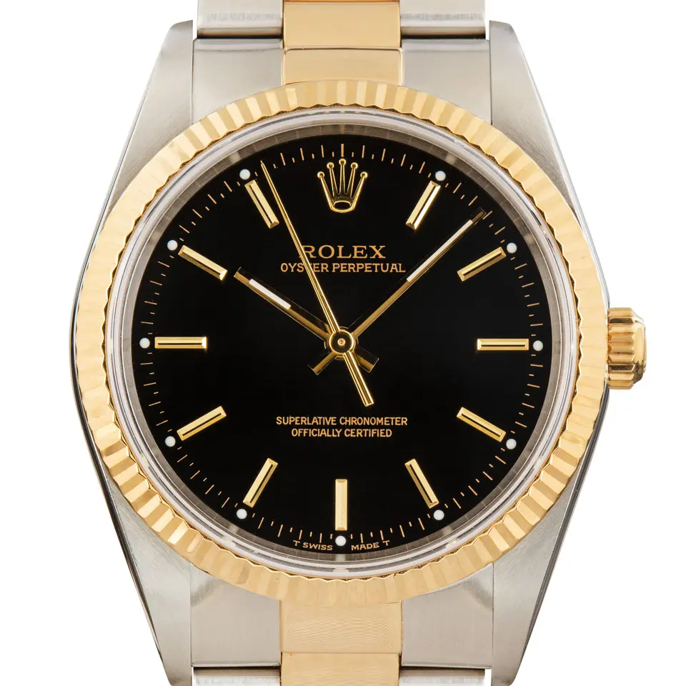Rolex Oyster Perpetual 34 14233 with a black dial, fluted yellow gold bezel and steel and gold Oyster bracelet, a pre-owned example, studio close-up of the case