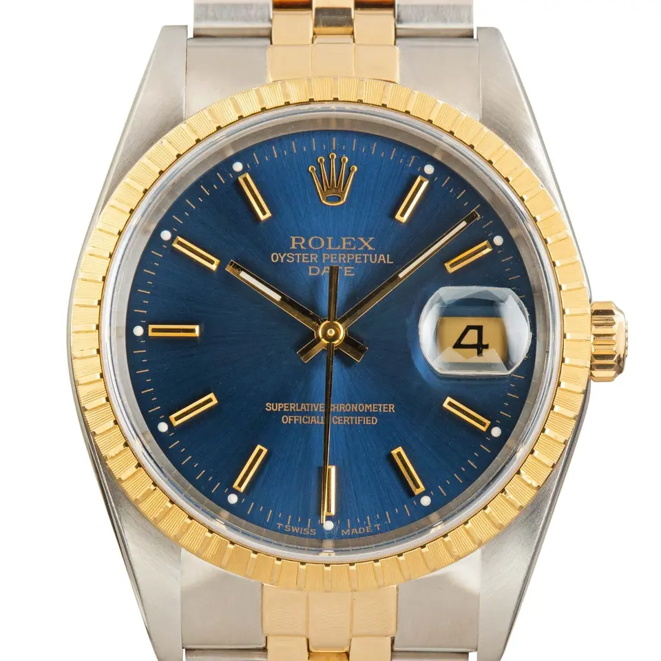 Rolex Oyster Perpetual Date 34 15223 with a blue dial with date window and engine-turned yellow gold bezel in steel and yellow gold on a Jubilee bracelet, a pre-owned example, studio close-up of the case