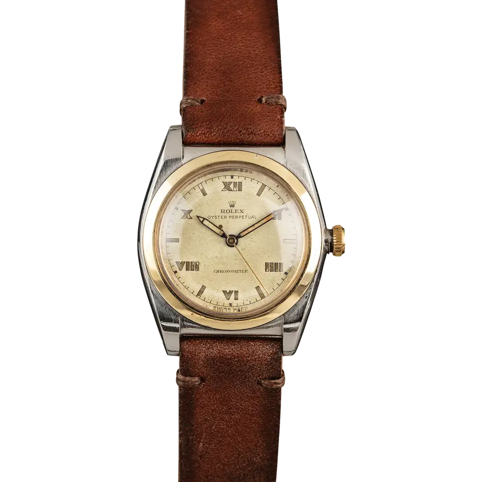 Rolex Oyster Perpetual 3133 with a cream Roman-numeral dial, smooth gold bezel and steel and gold bubbleback case on a brown leather strap, a pre-owned example, front view of the whole watch