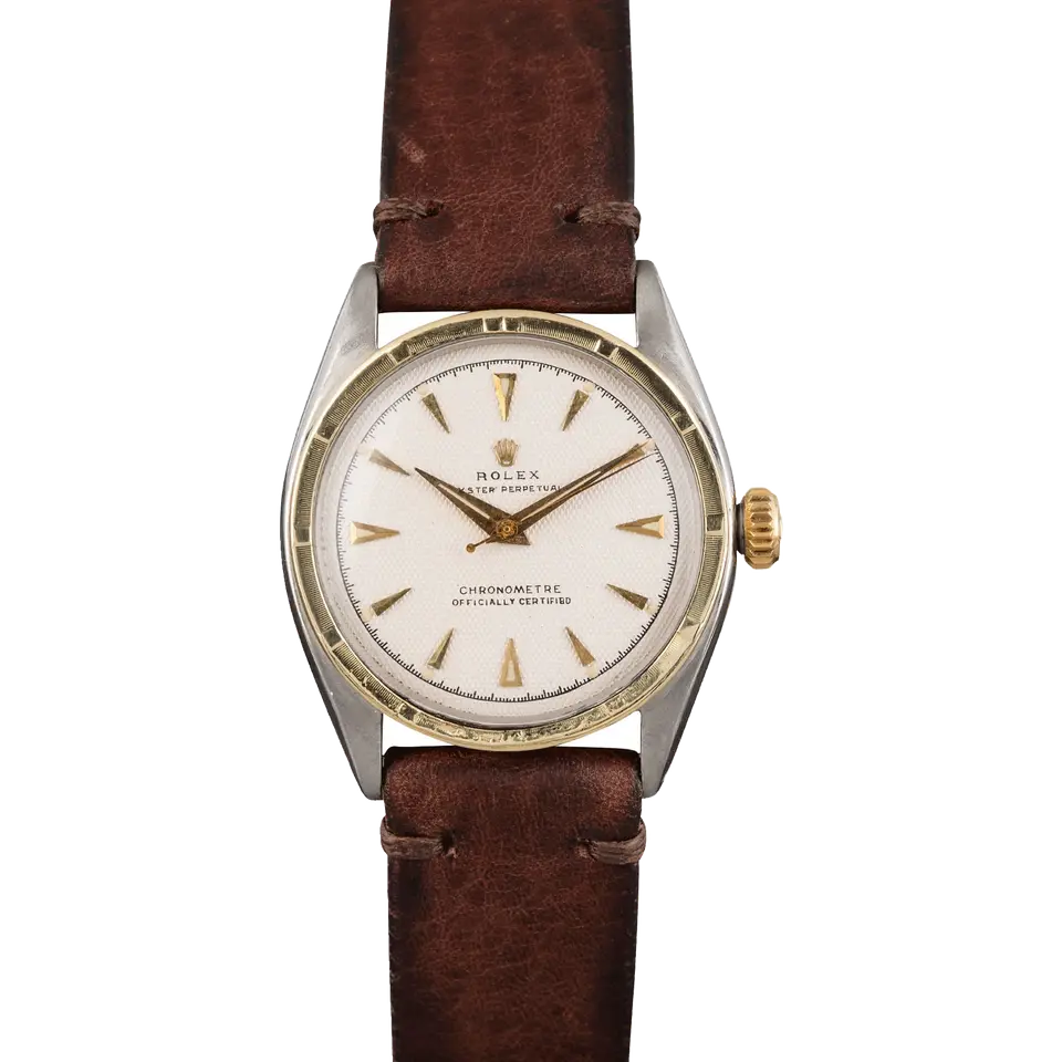 Rolex Oyster Perpetual 34 6085 with a white textured dial with arrow markers, engine-turned gold bezel and steel and gold case on a brown leather strap, a pre-owned example, front view of the whole watch