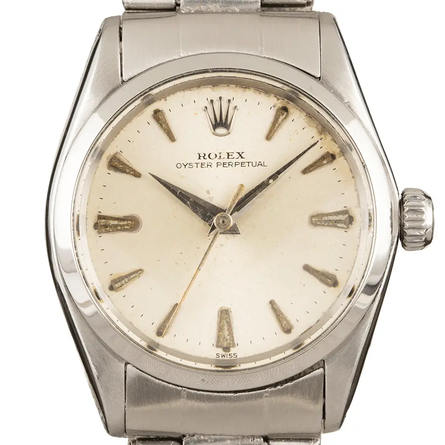 Rolex Oyster Perpetual 6548 with a silver dial with arrow markers, smooth steel bezel and steel Oyster bracelet, a pre-owned example, studio close-up of the case