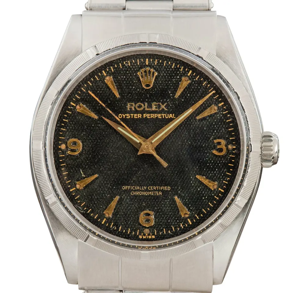 Rolex Oyster Perpetual 6565 with a black honeycomb dial with 3, 6 and 9 numerals, engine-turned steel bezel and steel Oyster bracelet, a pre-owned example, studio close-up of the case