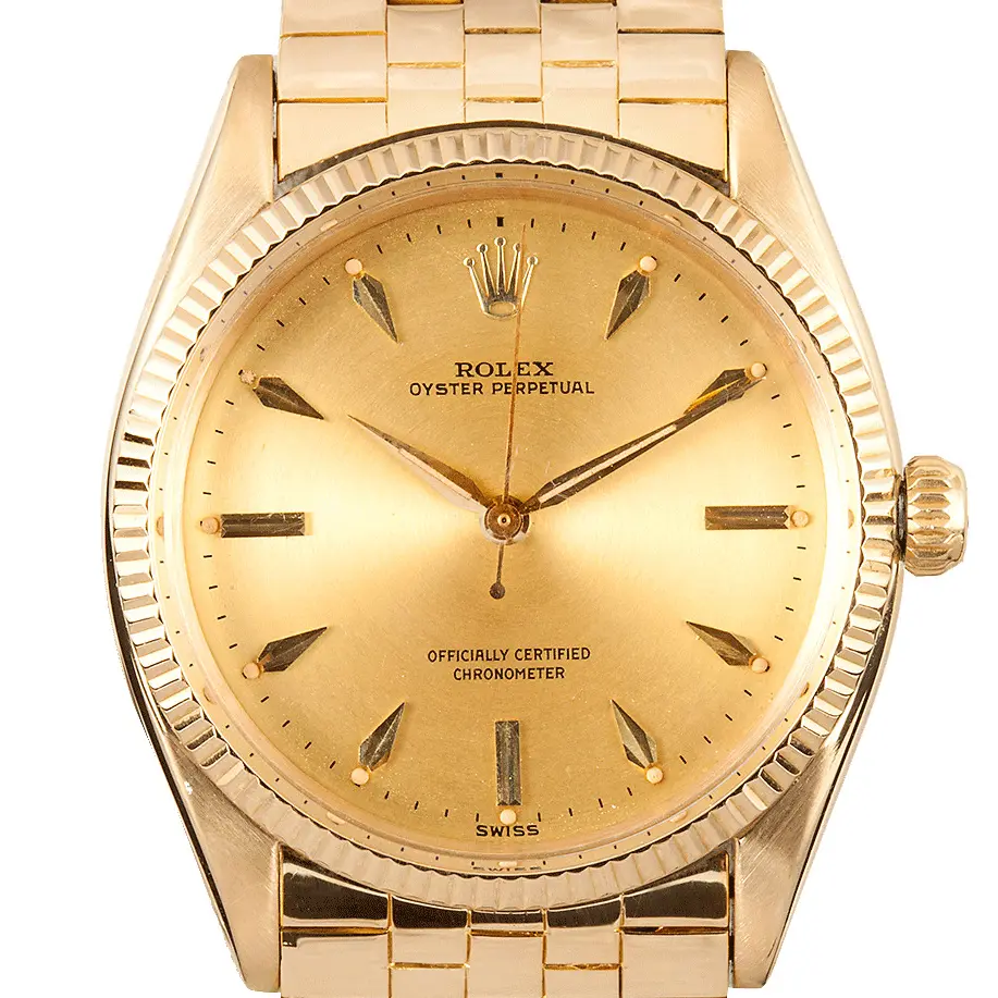 Rolex Oyster Perpetual 34 6567 with a champagne dial with arrow markers, engine-turned yellow gold bezel and yellow gold bracelet, a pre-owned example, studio close-up of the case