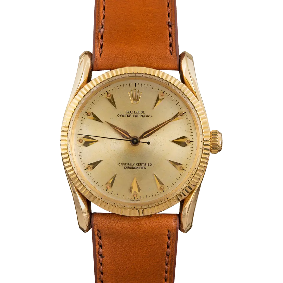 Rolex Oyster Perpetual 6593 with a champagne dial with arrow markers, fluted gold bezel and gold case on a tan leather strap, a pre-owned example, front view of the whole watch