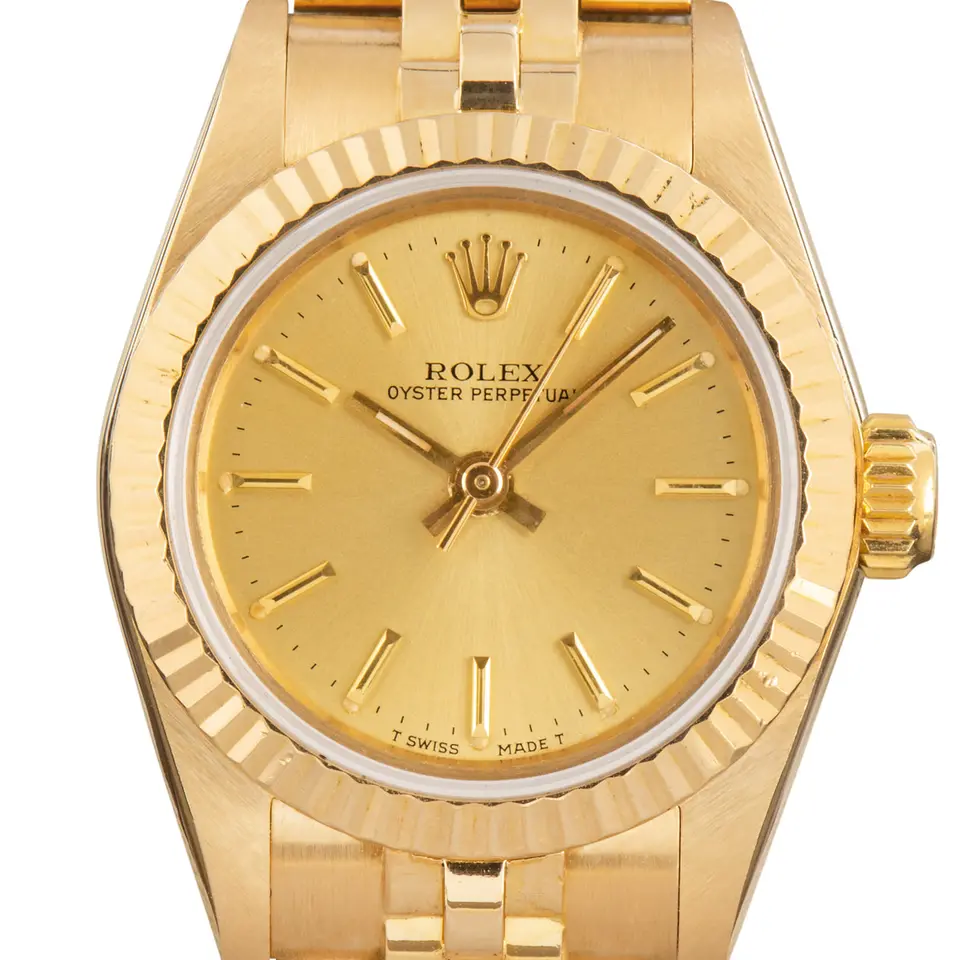 Rolex Oyster Perpetual 24 67198 with a champagne dial, fluted yellow gold bezel and yellow gold Jubilee bracelet, a pre-owned example, studio close-up of the case