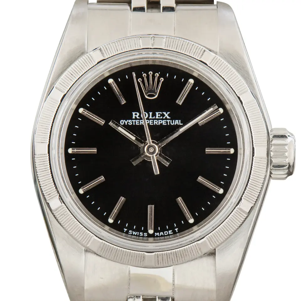 Rolex Oyster Perpetual 26 67230 with a black dial, engine-turned steel bezel and steel Oyster bracelet, a pre-owned example, studio close-up of the case