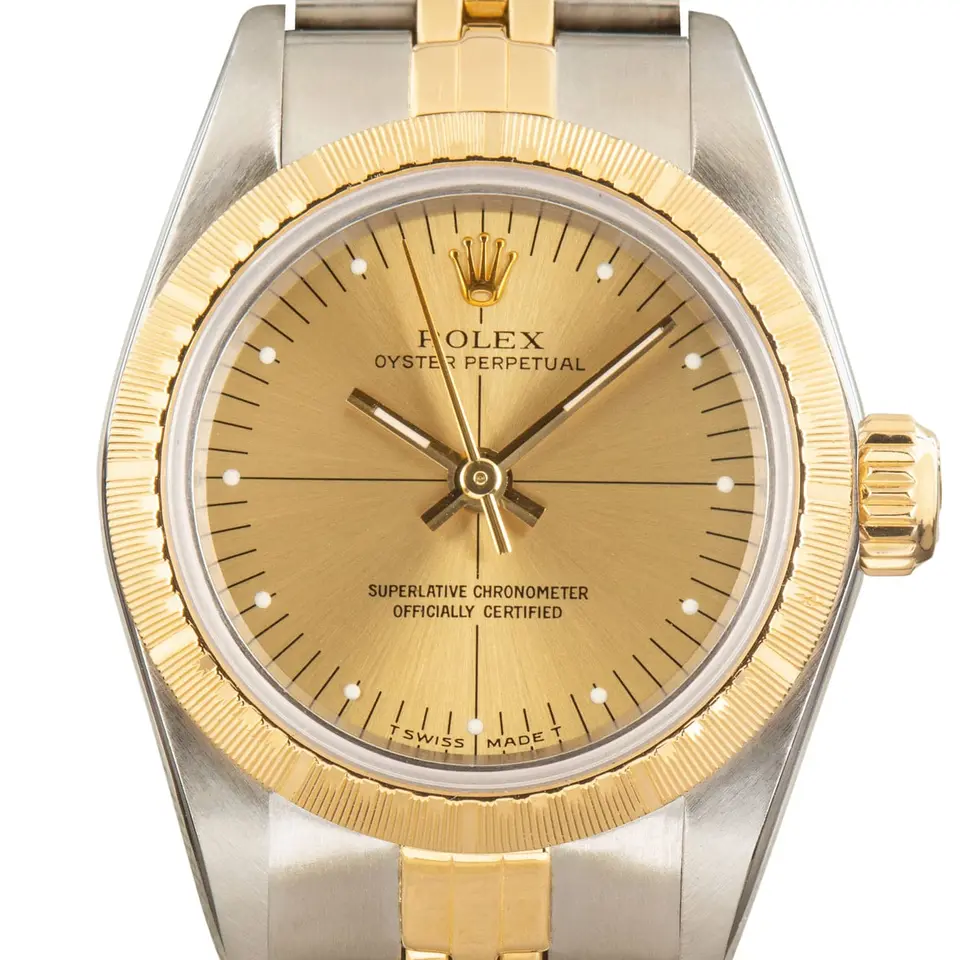 Rolex Ladies Oyster Perpetual 67243 with a champagne dial, engine-turned yellow gold bezel and steel and gold Jubilee bracelet, a pre-owned example, studio close-up of the case