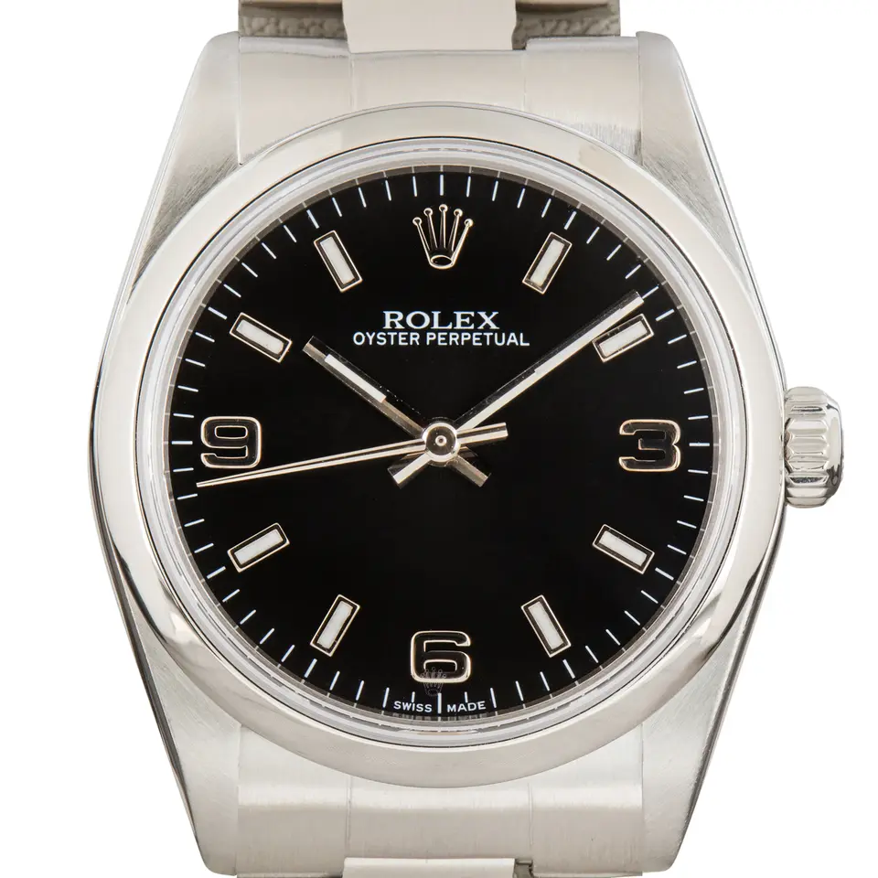 Rolex Oyster Perpetual 31 77080 with a black dial with 3, 6 and 9 numerals and smooth steel bezel on an Oyster bracelet, a pre-owned example, studio close-up of the case