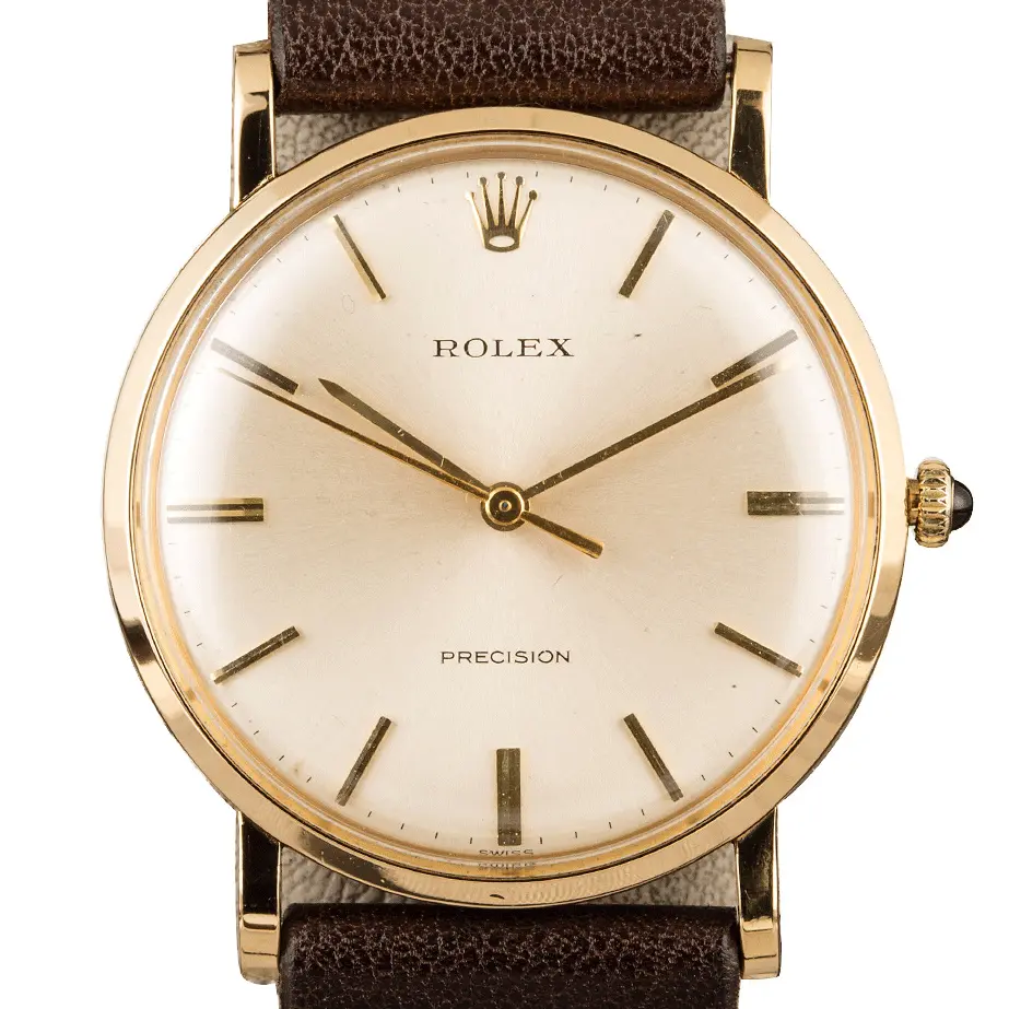 Rolex Precision 9659 with a silver Precision dial, round yellow gold case on a brown leather strap, a pre-owned example, studio close-up of the case