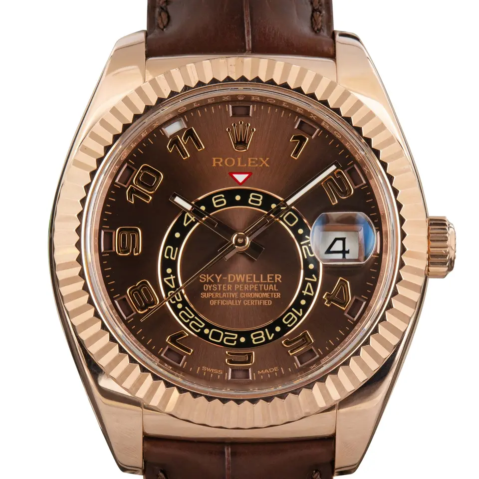 Rolex Sky-Dweller 326135 with a chocolate dial with Arabic numerals and fluted Everose bezel in Everose gold on a brown leather strap, a pre-owned example, studio close-up of the case