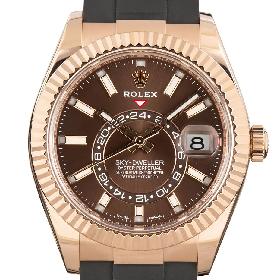 Rolex Sky-Dweller 326235 with a chocolate dial and fluted bezel in Everose gold on a black Oysterflex strap, a pre-owned example, studio close-up of the case