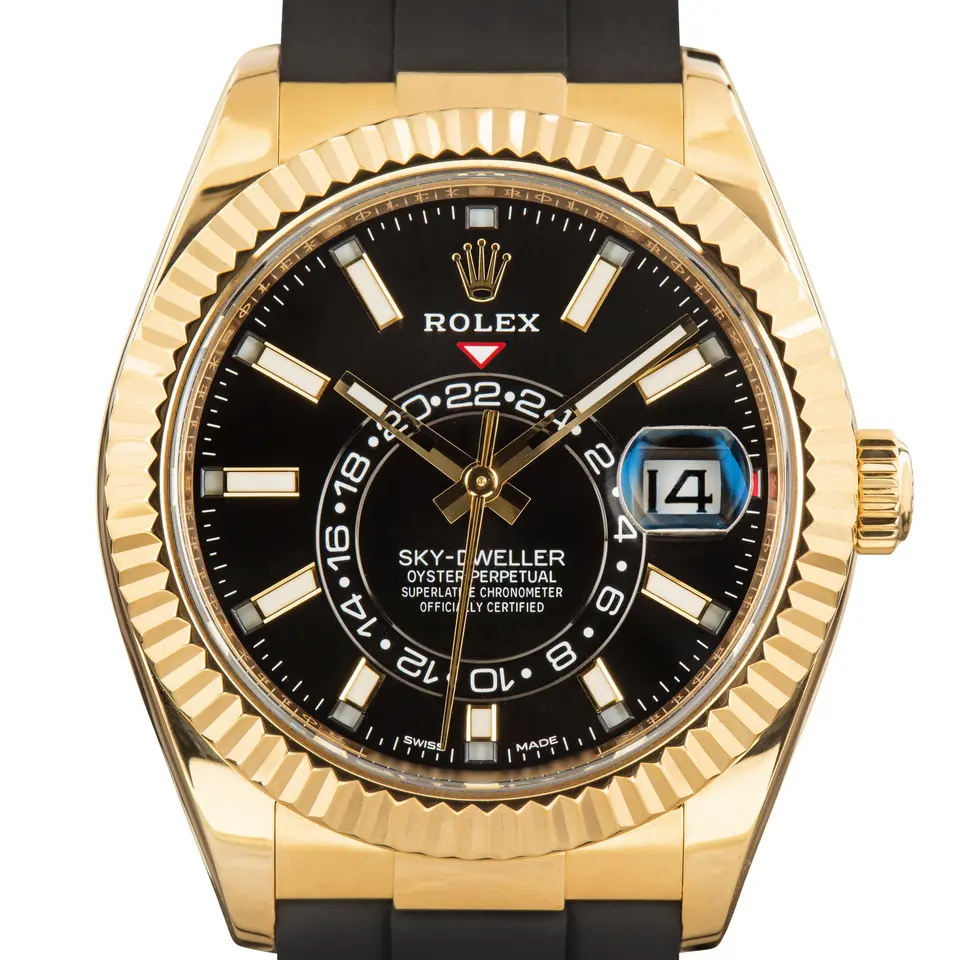 Rolex Sky-Dweller 326238 with a black dial and fluted bezel in yellow gold on a black Oysterflex strap, a pre-owned example, studio close-up of the case