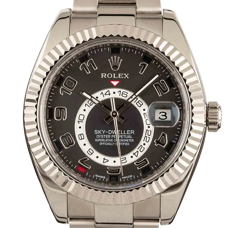 Rolex Sky-Dweller 326939 with a black dial with Arabic numerals, annual-calendar apertures and a fluted white gold bezel on a white gold Oyster bracelet, a pre-owned example, studio close-up of the case