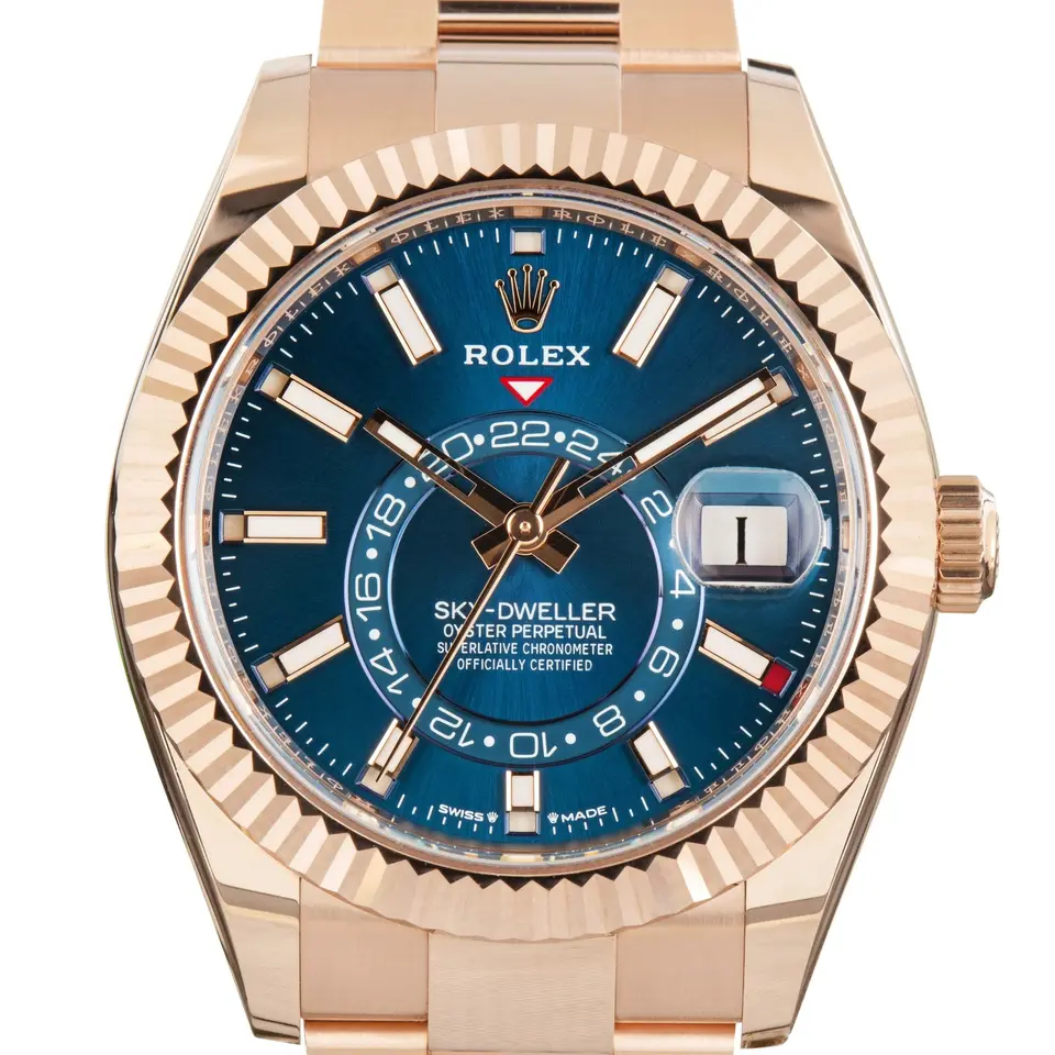 Rolex Sky-Dweller 336935 with a blue-green dial and a fluted Everose gold bezel, a pre-owned example, studio close-up of the case