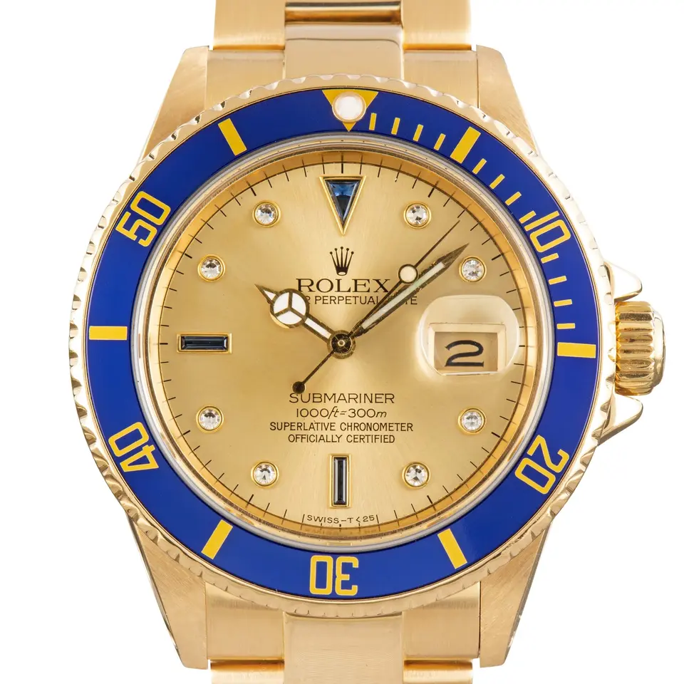 Rolex Submariner Date 16808 with a champagne dial with gem-set markers and blue bezel in yellow gold on an Oyster bracelet, a pre-owned example, studio close-up of the case