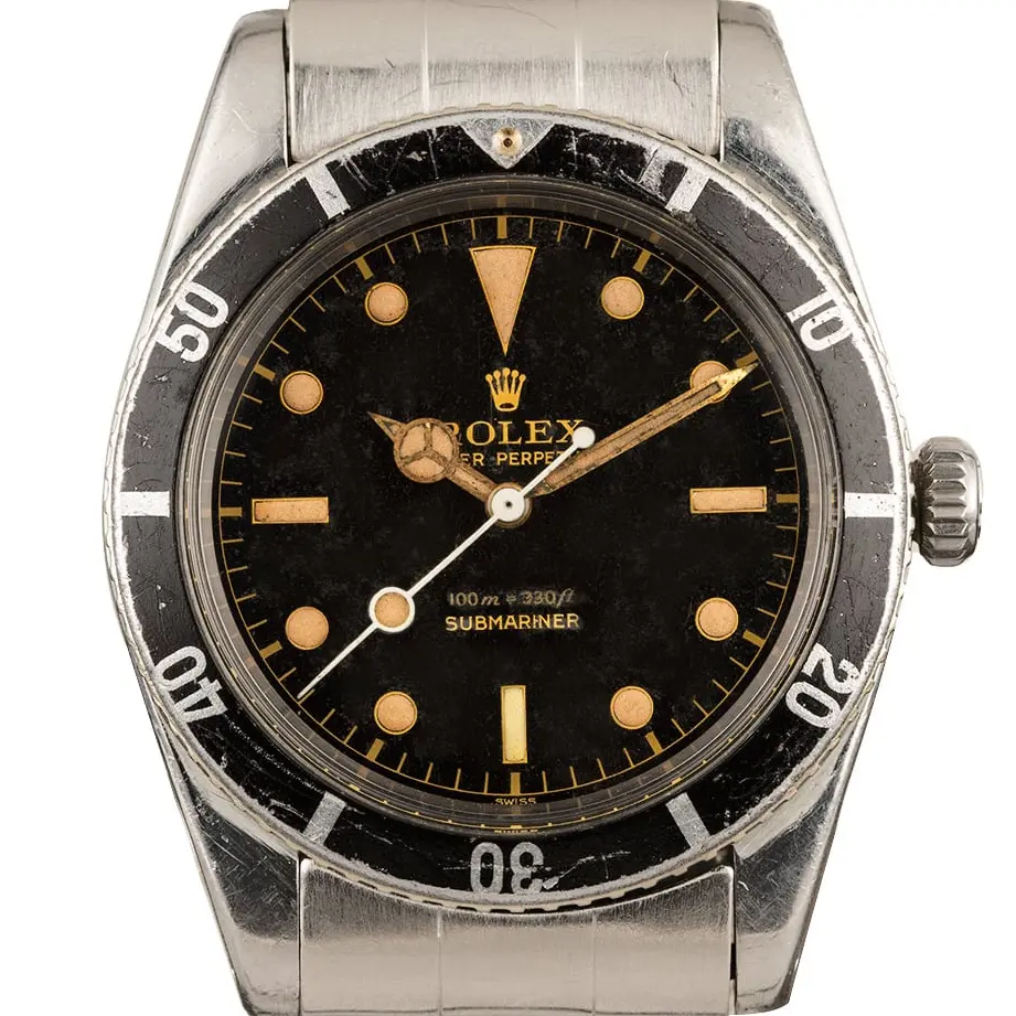 Rolex Submariner 6536 with a black gilt dial and aged black bezel insert on a steel bracelet, a pre-owned example, studio close-up of the case
